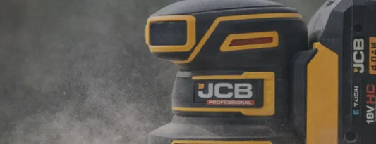 Zbliżenie narzędzia JCB Professional z akumulatorem 18V na zapylonym tle