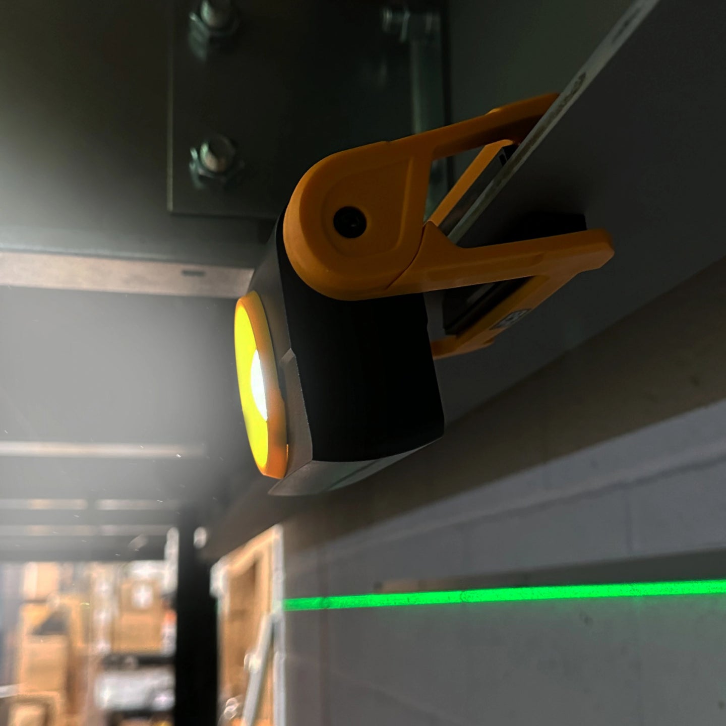 Lampa robocza JCB zawieszona na metalowym profilu podczas pracy