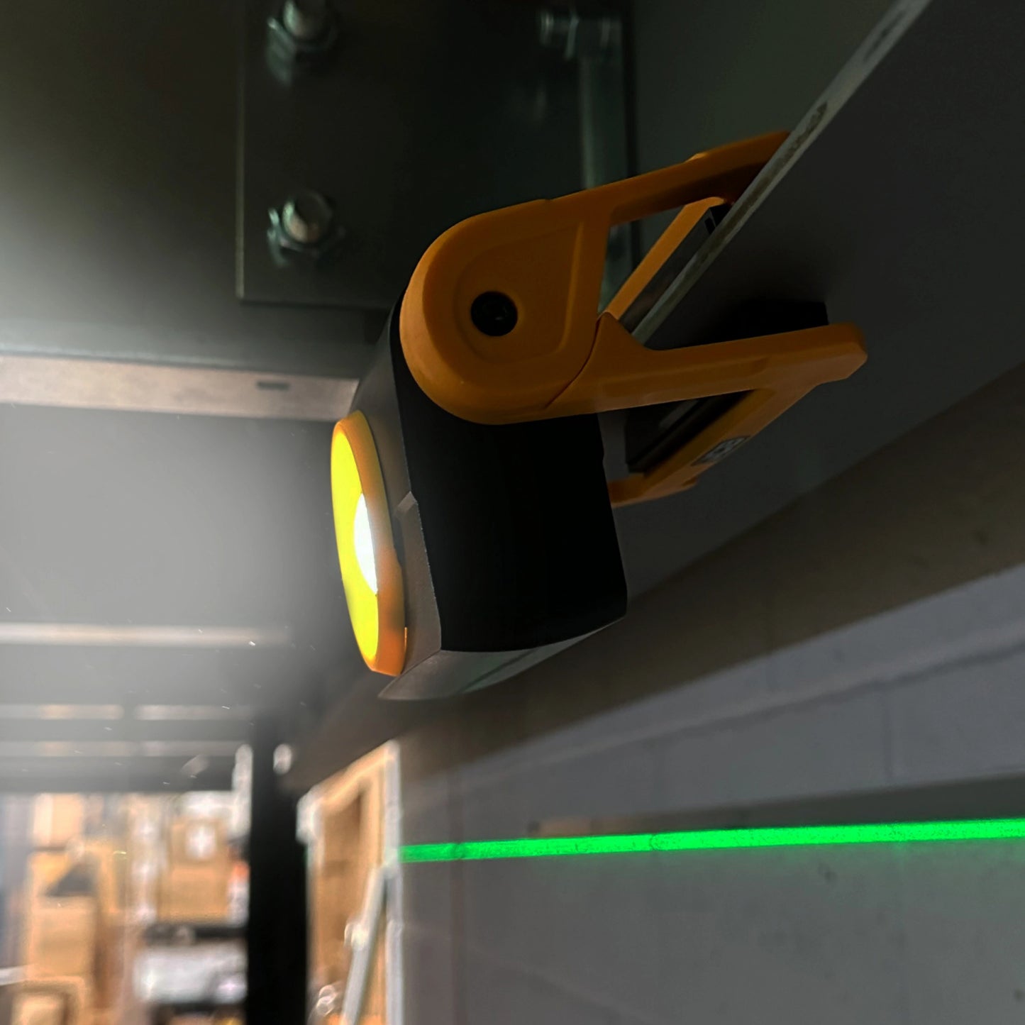 Lampa robocza JCB zawieszona na metalowym profilu podczas pracy