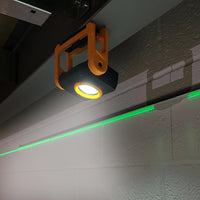 Lampa robocza JCB zawieszona pod belką, oświetlająca ścianę roboczą