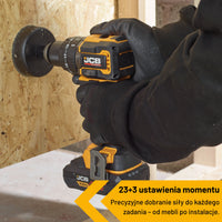 Wiertarko wkrętarka akumulatorowa 75 Nm JCB Professional JCB 18PCD 75 podczas wiercenia otwornicą w płycie OSB tekst 23+3 ustawienia momentu precyzyjne dobranie siły do każdego zadania od mebli po instalacje
