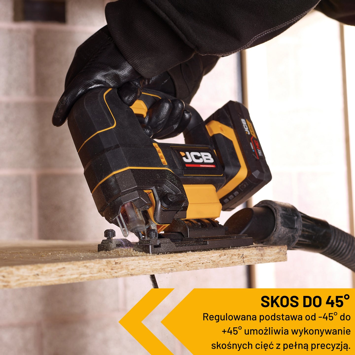 Wyrzynarka JCB 18V tnie płytę pod kątem podłączony wąż do odsysania pyłu tekst skos do 45 stopni regulowana podstawa od minus 45 do plus 45 