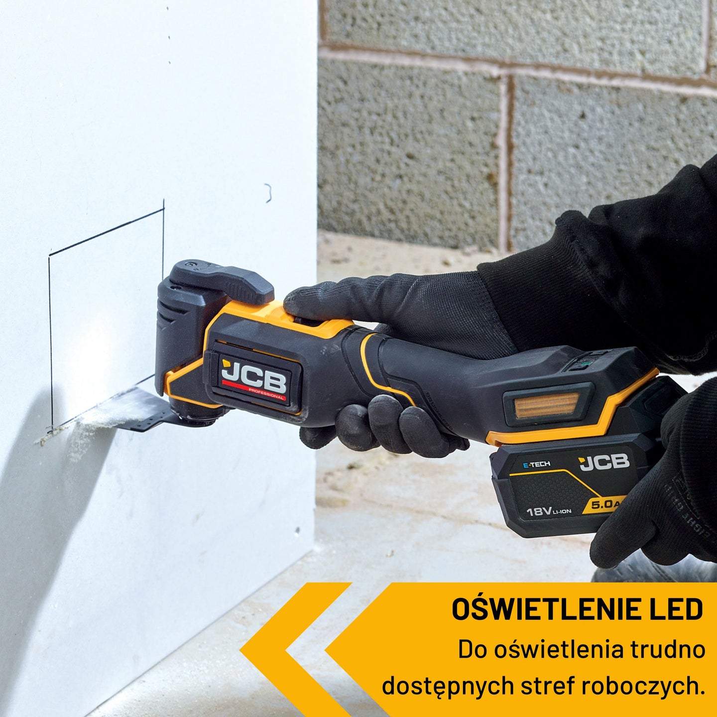 Narzędzie wielofunkcyjne JCB 18V podczas wycinania otworu w płycie oświetlenie LED świeci na materiał tekst oświetlenie LED do trudno dostępnych stref roboczych