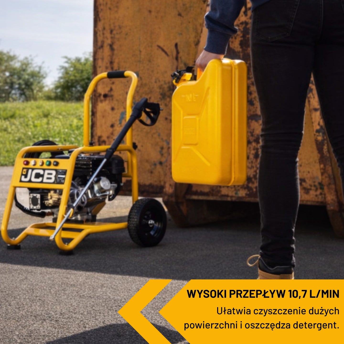 Myjka ciśnieniowa JCB PW7532P24 gotowa do pracy przy kontenerze pracownik podchodzi do niej z kanistrem tekst wysoki przepływ 10,7 l min ułatwia czyszczenie dużych powierzchni i oszczędza detergent
