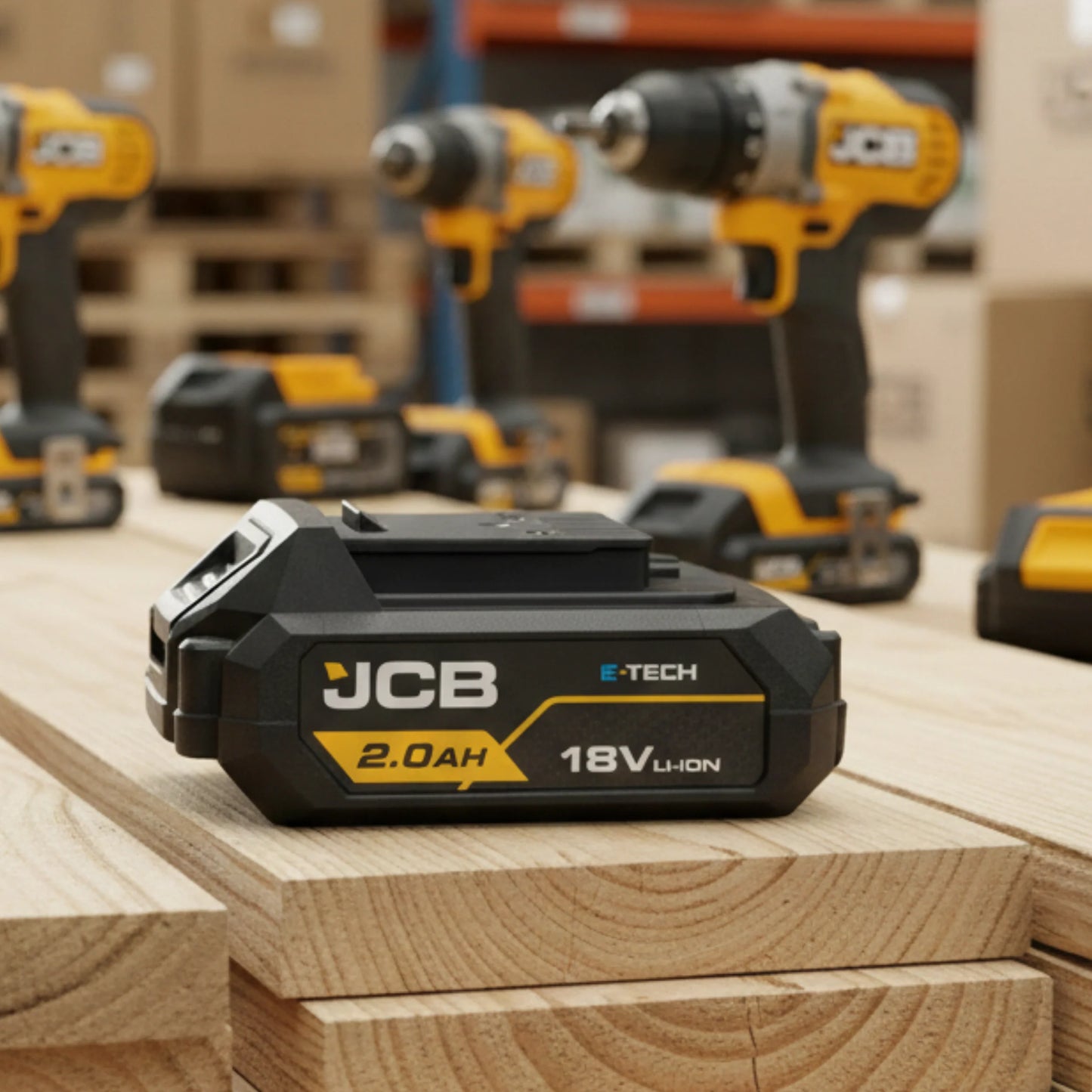 akumulator li-ion JCB E-Tech 18V 2.0Ah na desce w magazynie z elektronarzędziami JCB w tle i tekstem zaawansowana ochrona przed przeładowaniem