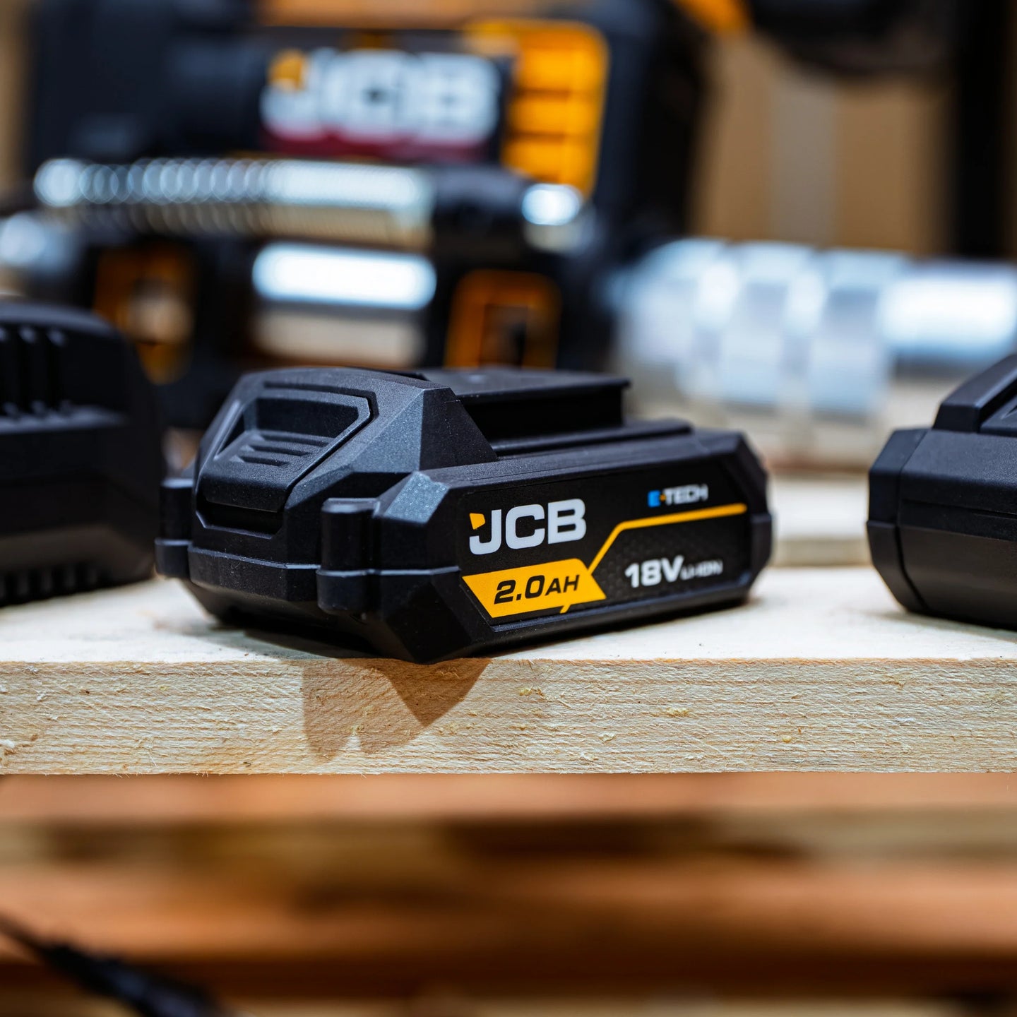 akumulator li-ion JCB 18V 2.0Ah na desce w warsztacie z tekstem zaawansowane chłodzenie i ochrona termiczna