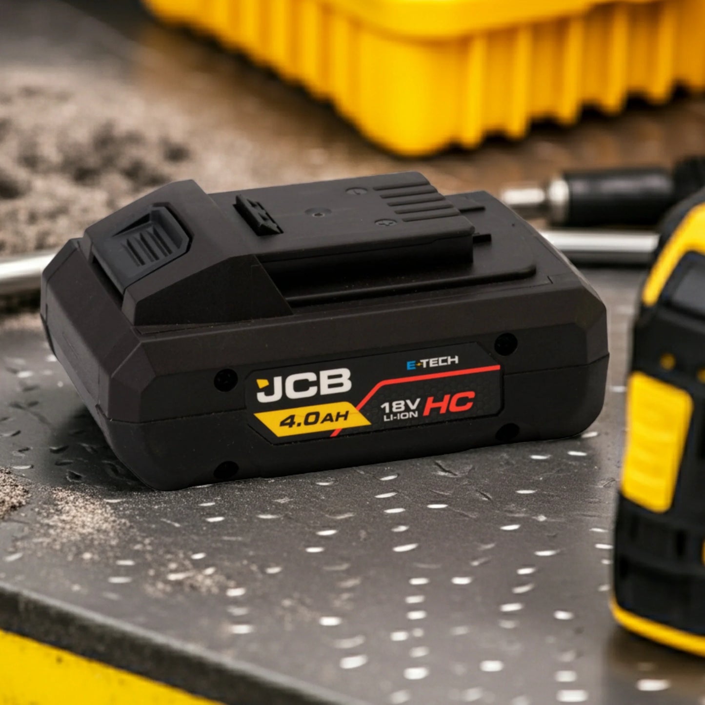 akumulator li-ion JCB E-Tech 18V HC 4.0Ah na metalowym blacie warsztatu z tekstem inteligentna komunikacja cyfrowa