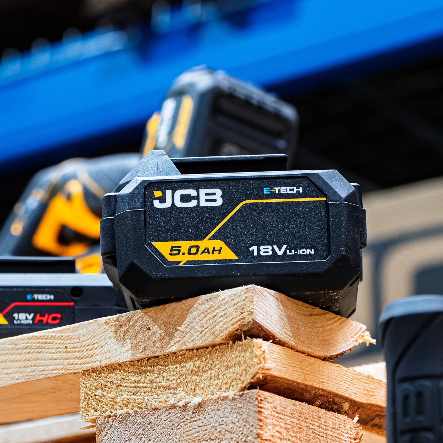 akumulator li-ion JCB E-Tech 18V 5.0Ah na desce z akumulatorem HC w tle i tekstem 4-diodowy wskaźnik naładowania