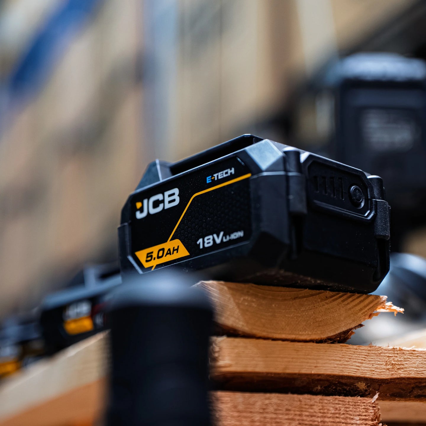 akumulator li-ion JCB E-Tech 18V 5.0Ah na desce w warsztacie z tekstem zaawansowana technologia chłodzenia