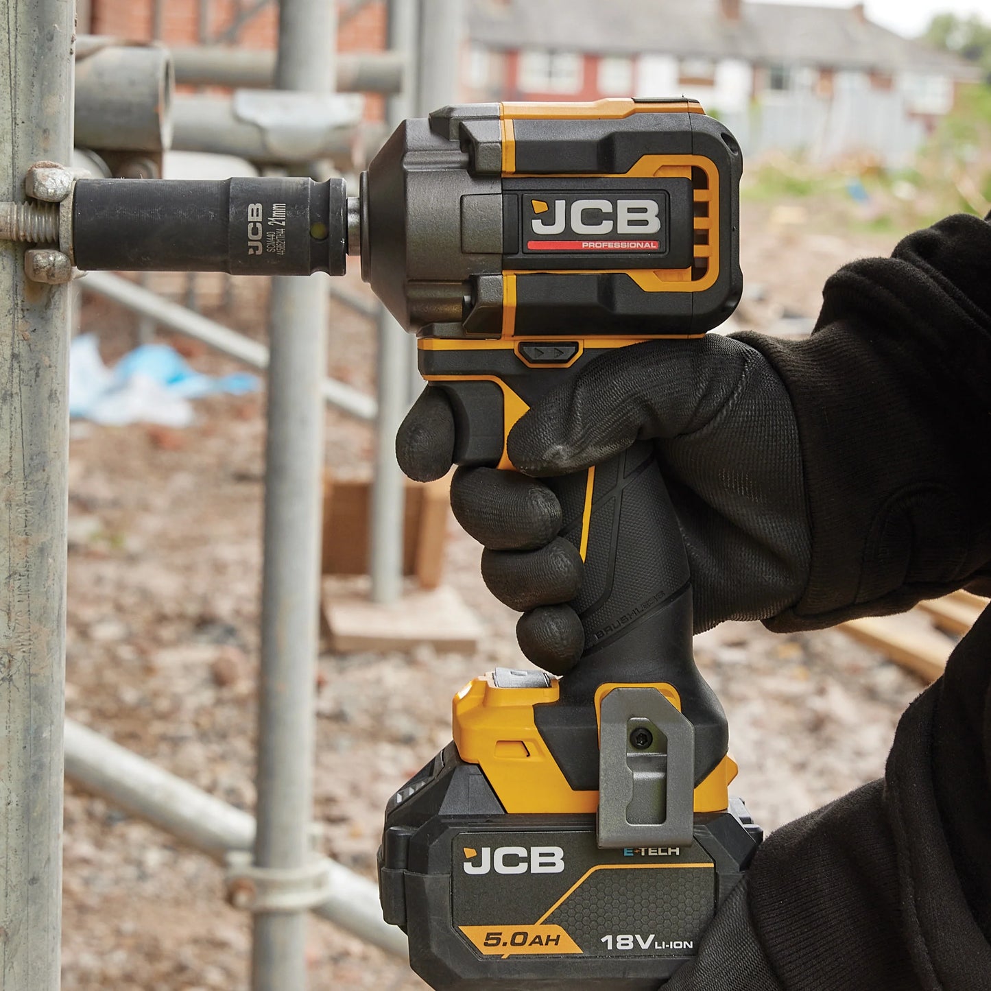 klucz udarowy akumulatorowy JCB Professional podczas dokręcania śrub na rusztowaniu na placu budowy z tekstem 4500 udarów/min