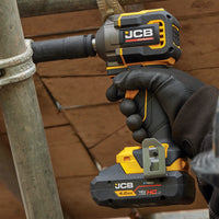 klucz udarowy JCB Professional 18V podczas dokręcania złącza rury w rękach operatora w rękawicy z tekstem Uchwyt 1/2 Square Drive