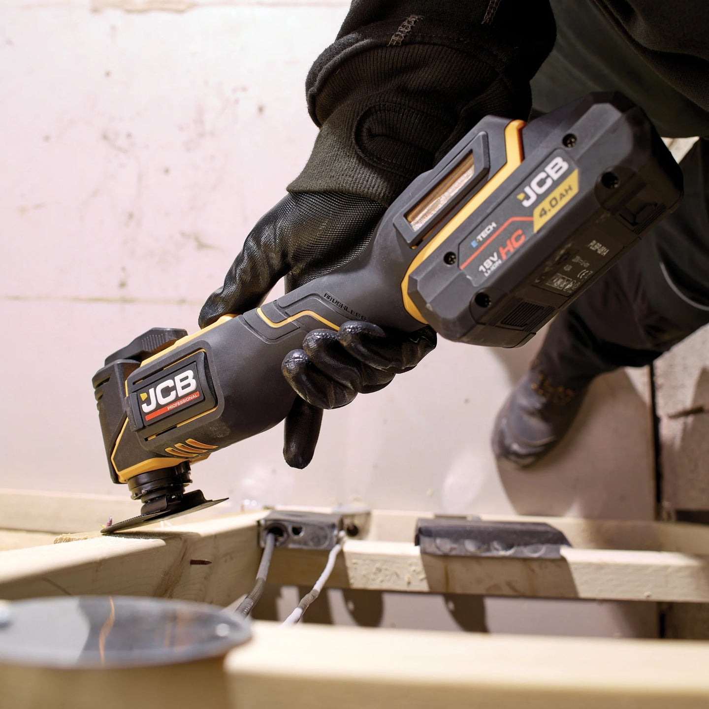 Multitool JCB 18V podczas cięcia trzymany przez pracownika tekst dziewięć poziomów prędkości i kąt oscylacji 3,6