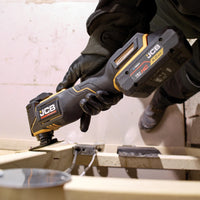 Multitool JCB 18V podczas cięcia trzymany przez pracownika tekst dziewięć poziomów prędkości i kąt oscylacji 3,6