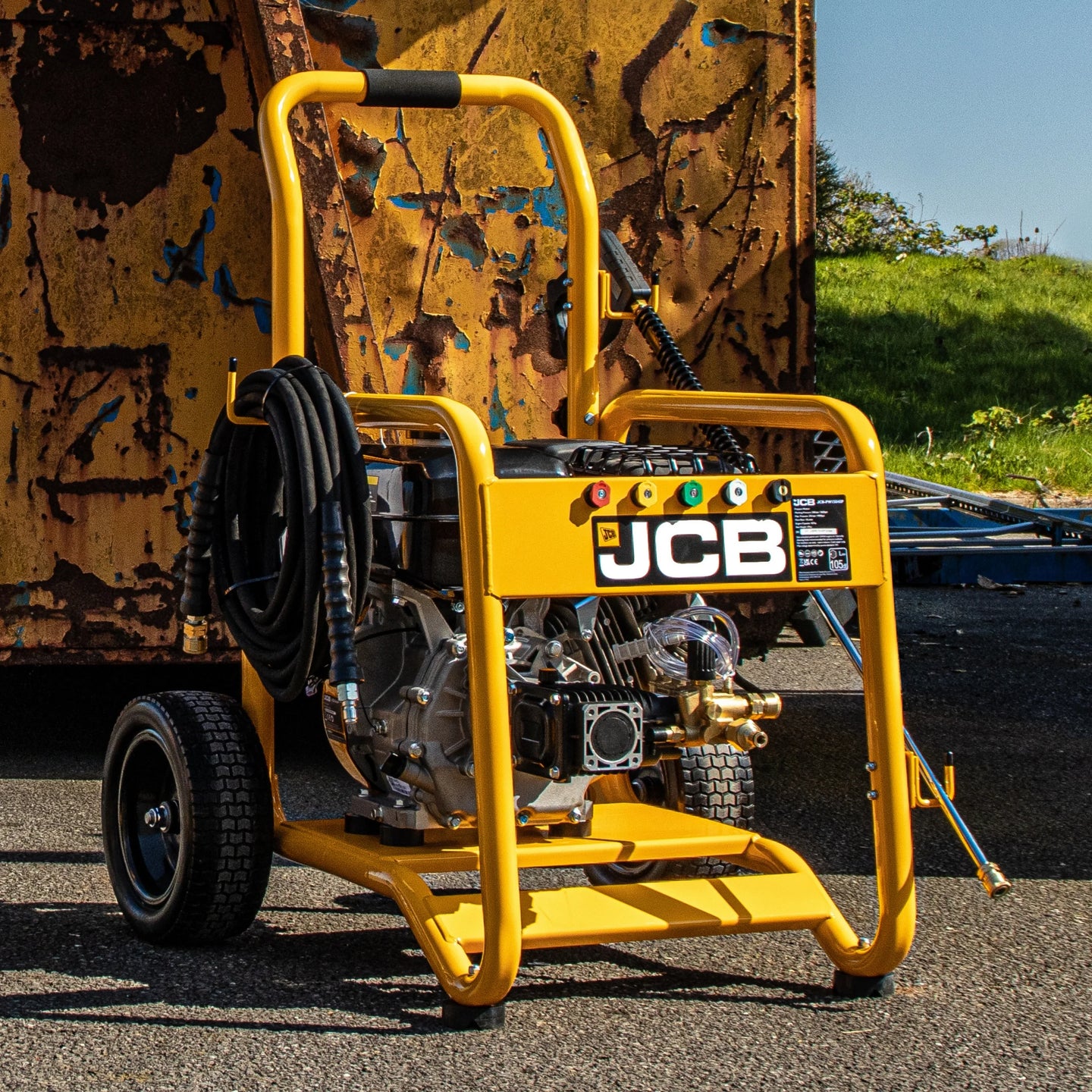 Myjka ciśnieniowa JCB PW7532P24 w żółtej stalowej ramie z pompą mosiężną annovi reverberi wężem zwiniętym na boku oraz zestawem dysz QD z tekstem o ich zastosowaniu zestaw dysz szybkozłącznych 0 15 25 40 do detergentu umożliwia dostosowanie strumienia do różnych potrzeb