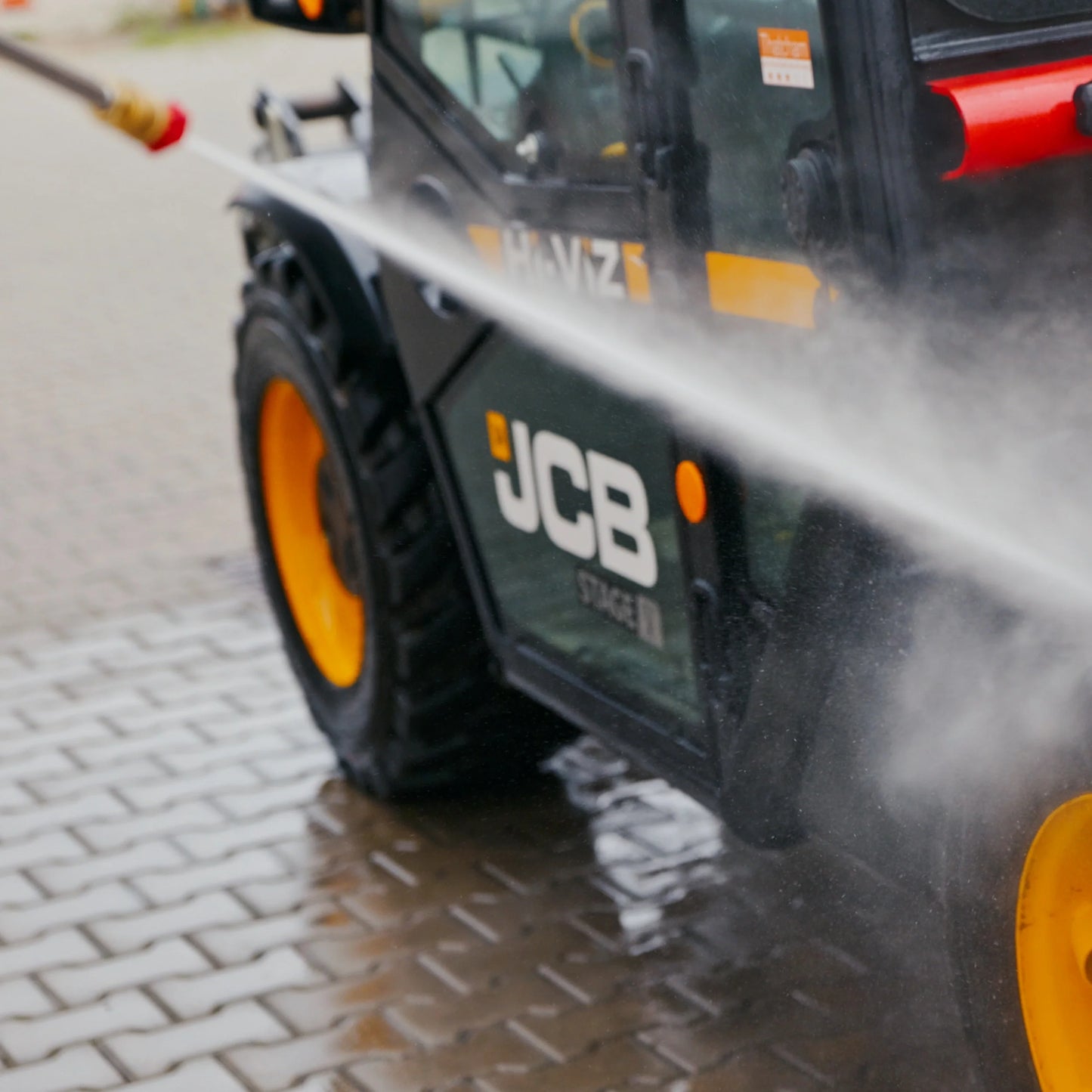 Myjka ciśnieniowa JCB PW7532P24 podczas pracy mycia maszyny JCB strumieniem wody tekst moc 213 bar myjka generuje ciśnienie robocze aż 213 bar 3100psi