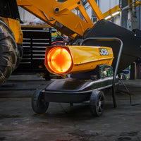 Nagrzewnica JCB SH215DP24 podczas pracy z rozżarzonym palnikiem, w tle maszyna JCB, tekst: Systemy bezpieczeństwa – czujniki płomienia, przegrzania i przepływu powietrza z automatycznym wyłączeniem