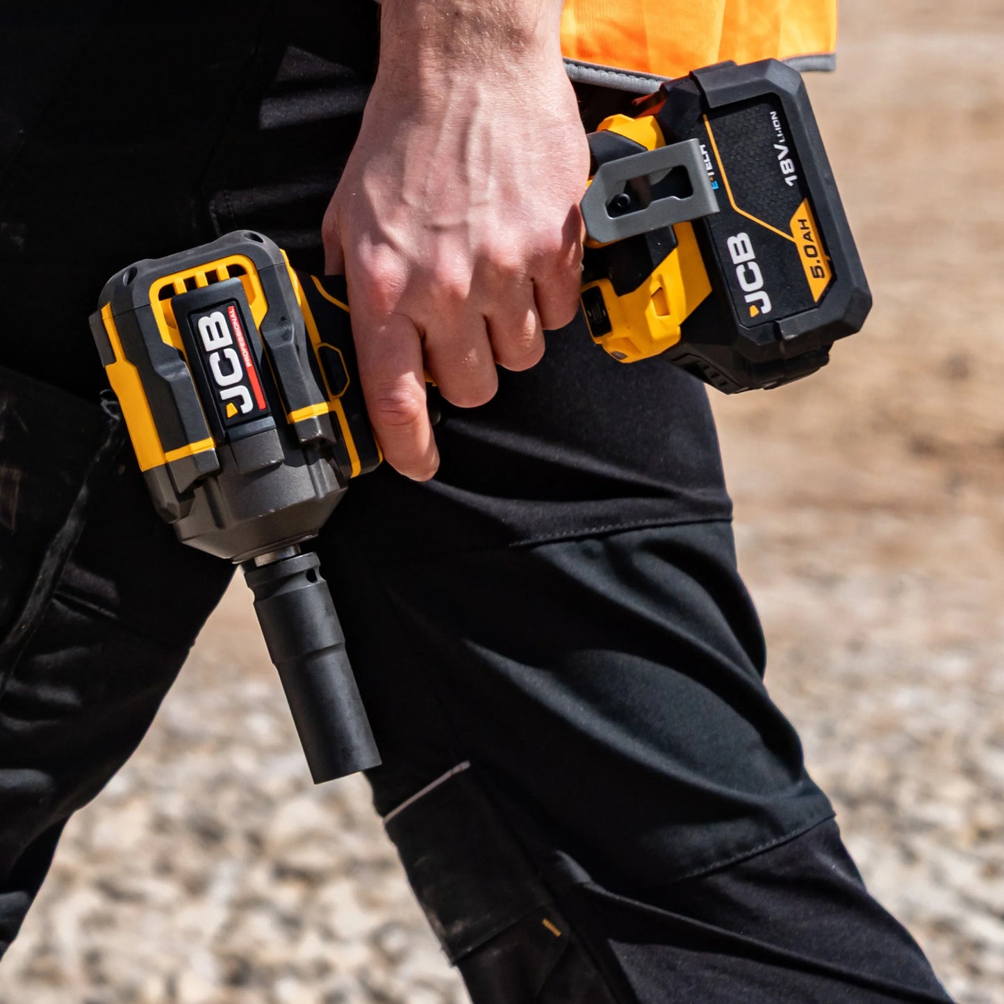 Zbliżenie na chwyt klucza udarowego JCB 18V z zestawu JCB-PRO18V-SERVKIT-zestaw-1 żółto-czarny napis BRUSHLESS hak do zawieszenia po prawej