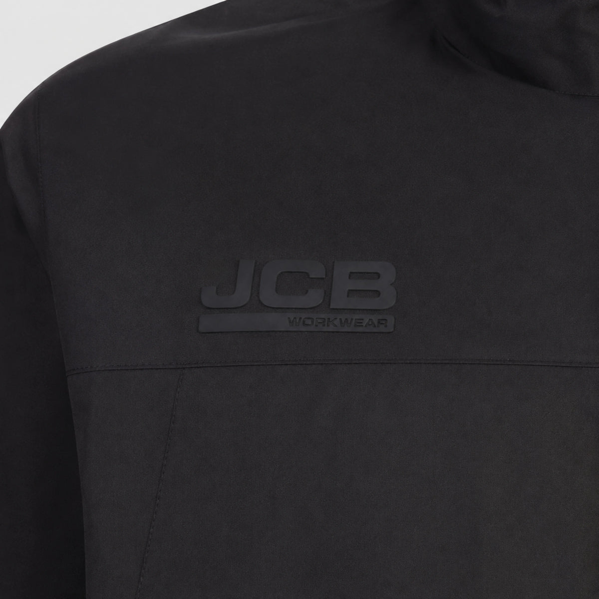Zbliżenie pleców kurtki JCB Workwear z czarnym logo marki na materiale