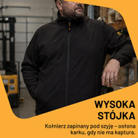 Mężczyzna w czarnej kurtce roboczej softshell JCB w warsztacie, tekst Wysoka stójka