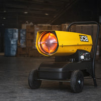 Nagrzewnica JCB SH215DP24 podczas pracy w magazynie, żółta obudowa, rozżarzony palnik od przodu